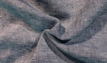 Load image into Gallery viewer, Close up image of denim blue yarn dye fabric. Fabric is bunched in the middle to show the drape, texture, and color variance of the linen fabric.
