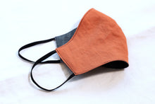 Load image into Gallery viewer, folded face mask on white background. Adobe color on front side and denim blue color on inside.