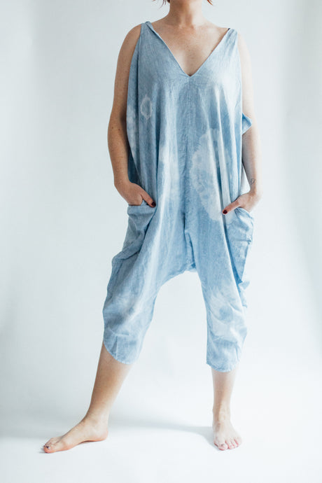 model stands with hands in pockets and legs spread apart wearing indigo tie dye jumpsuit